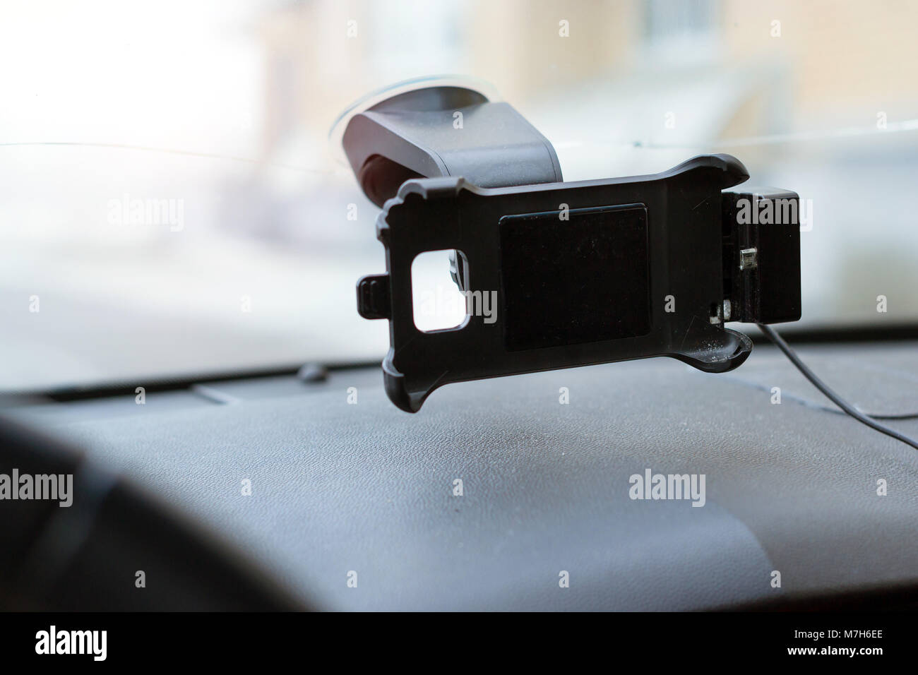 Car smartphone holder attached to the windscreen of automobile. Accessories for vehicles, for ease of control a car in the way. Phone holder with char Stock Photo