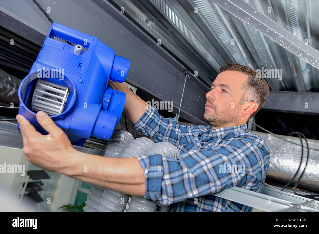 Electrician fitting a ventilation system Stock Photo Alamy