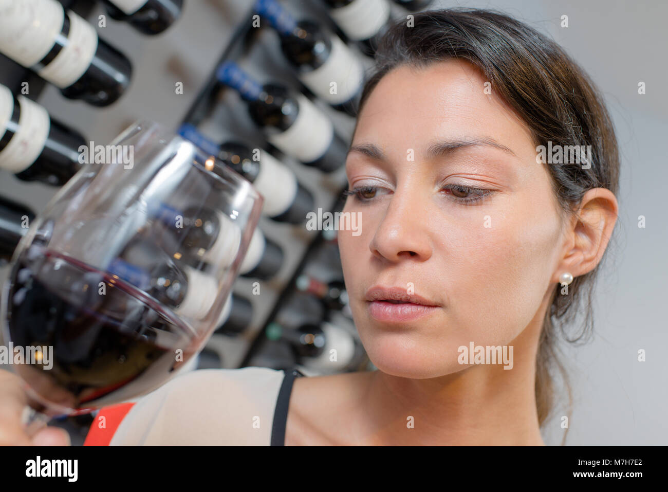 Lady holding glass of wine, looking pensive Stock Photo - Alamy