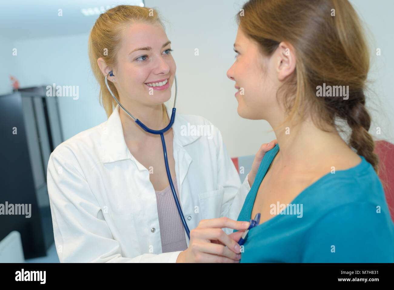 female doctor listening to patients heart with stethoscope Stock Photo ...
