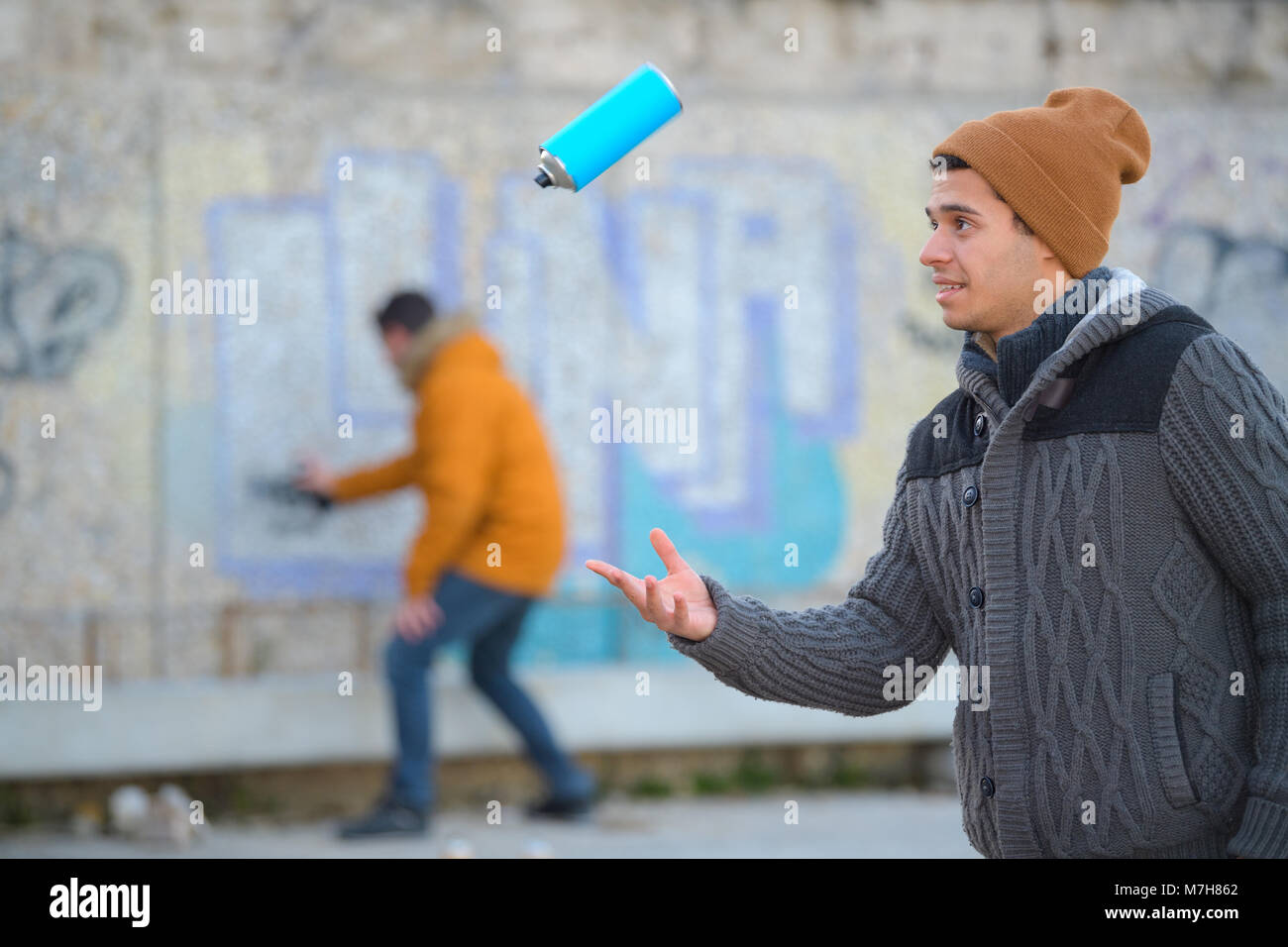 graffiti artist playing with spraying can Stock Photo - Alamy