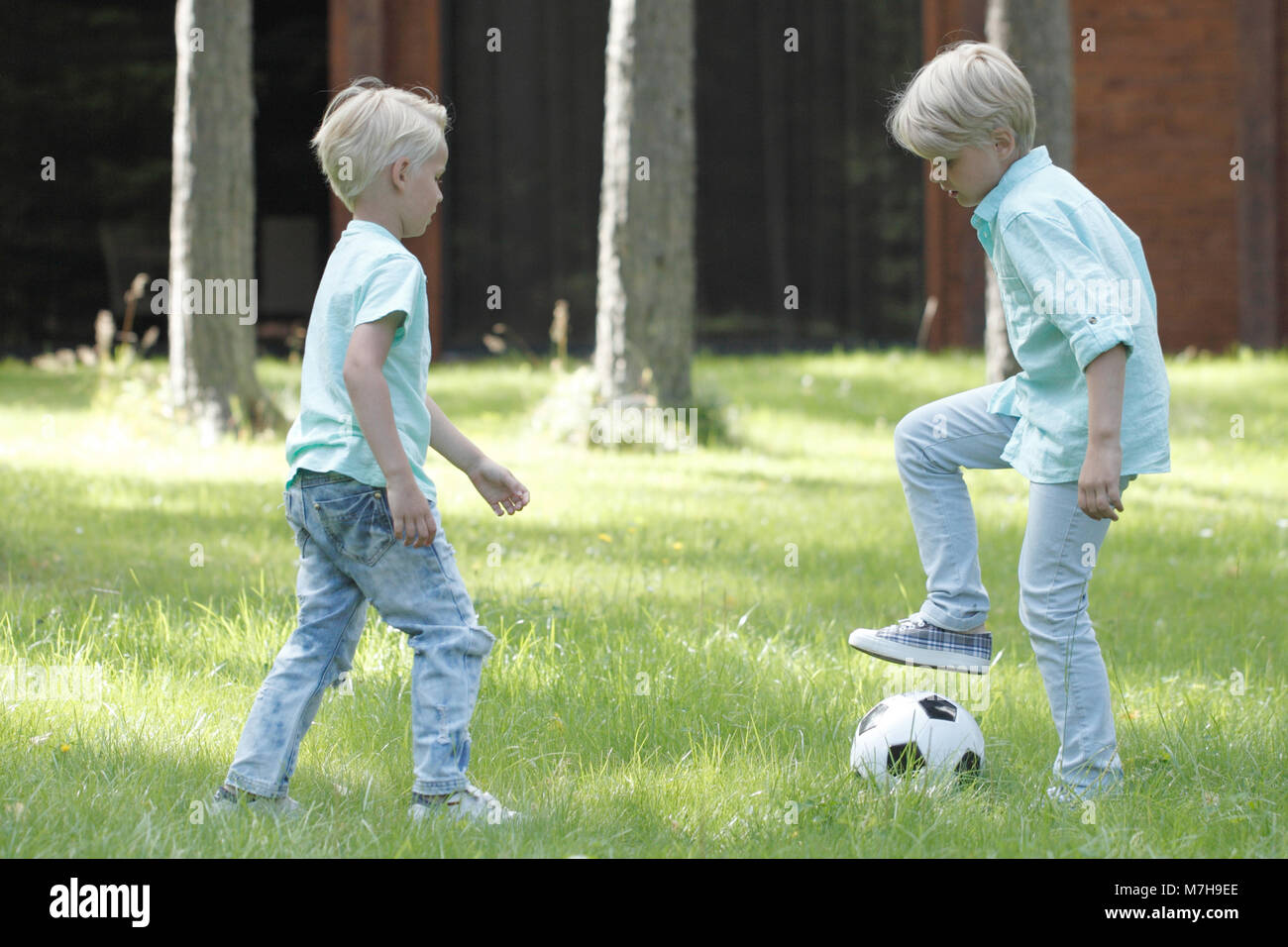 Happy children playing football in summer park Stock Photo - Alamy