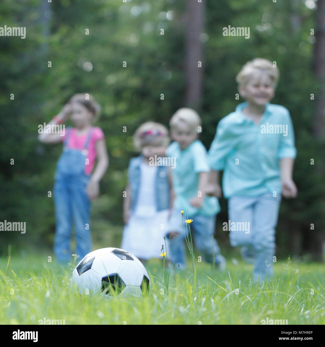 Happy children playing football in summer park Stock Photo - Alamy