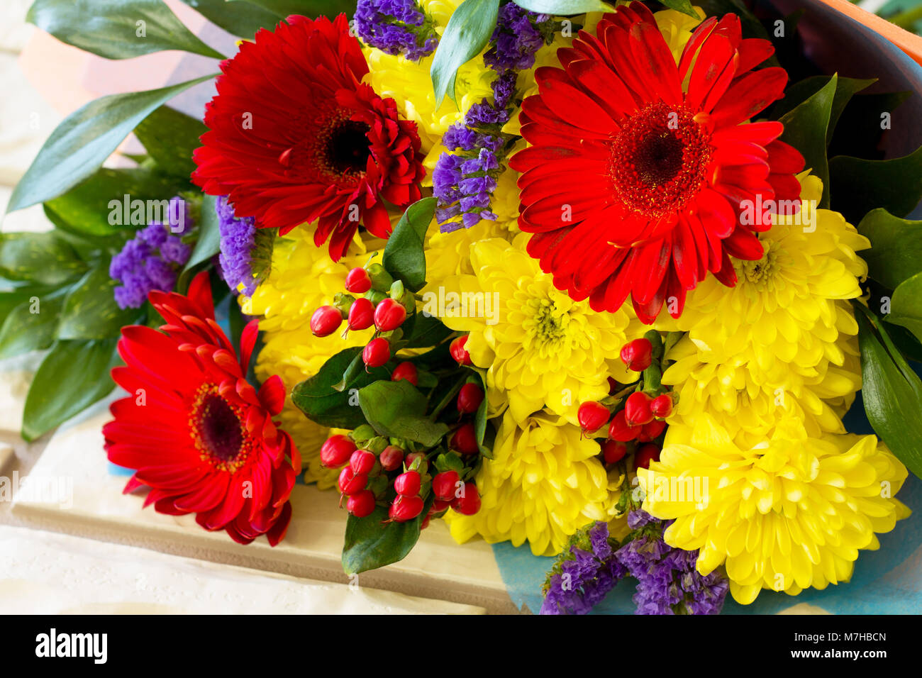 A wedding story or background Mother's Day. Bouquet of gerbera with  chrysanthemums and present on a blue stone background or concrete Stock  Photo - Alamy