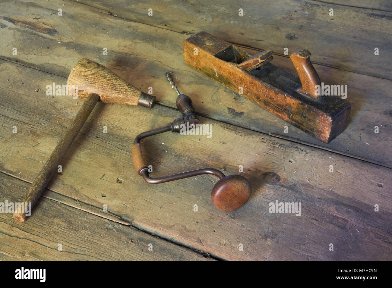 Old mallet manual hand drill and hand plane on wooden floor in