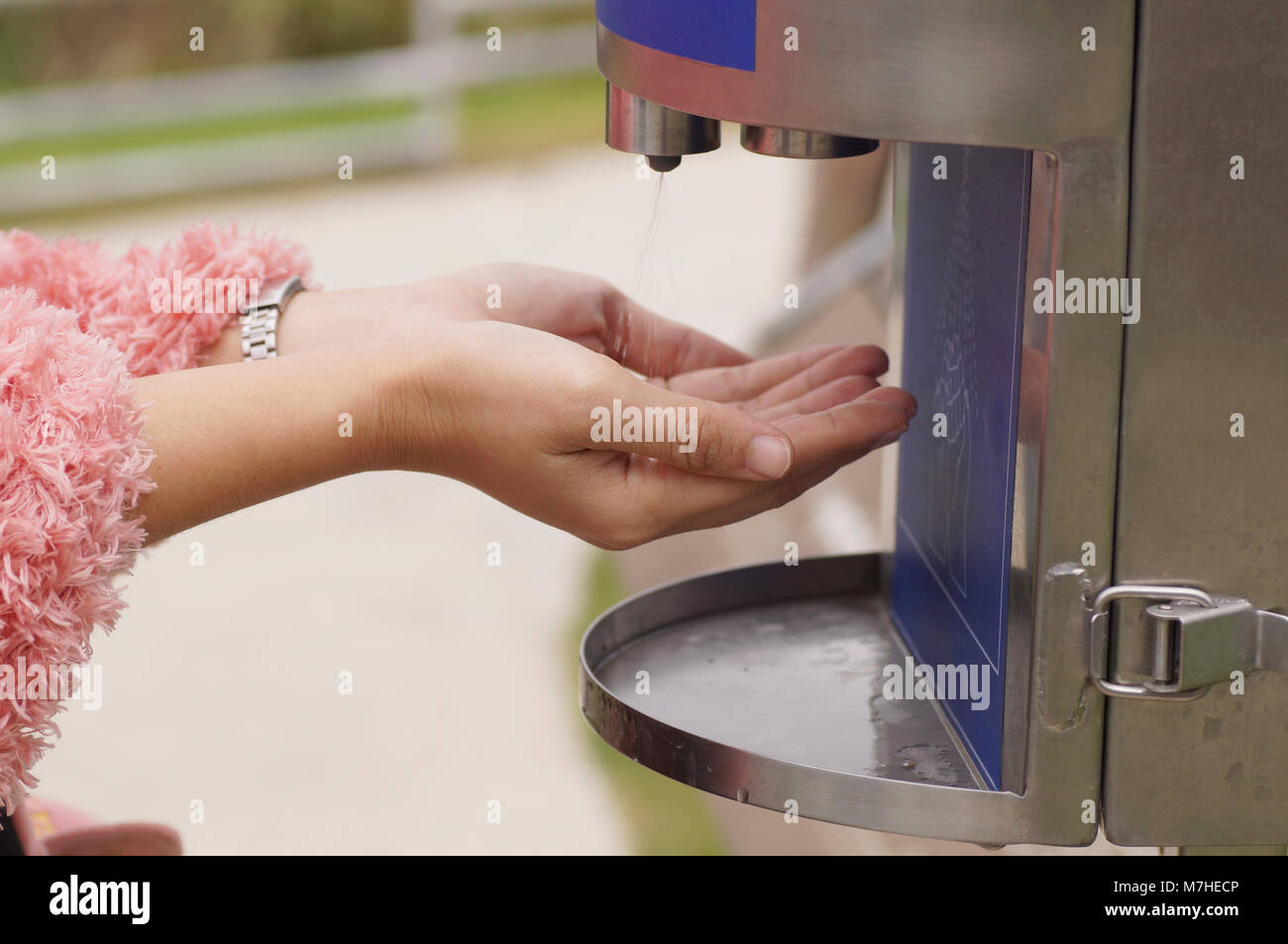 hand of women washing with automatic alcohol dispenser for cleaning and healthy care Stock Photo