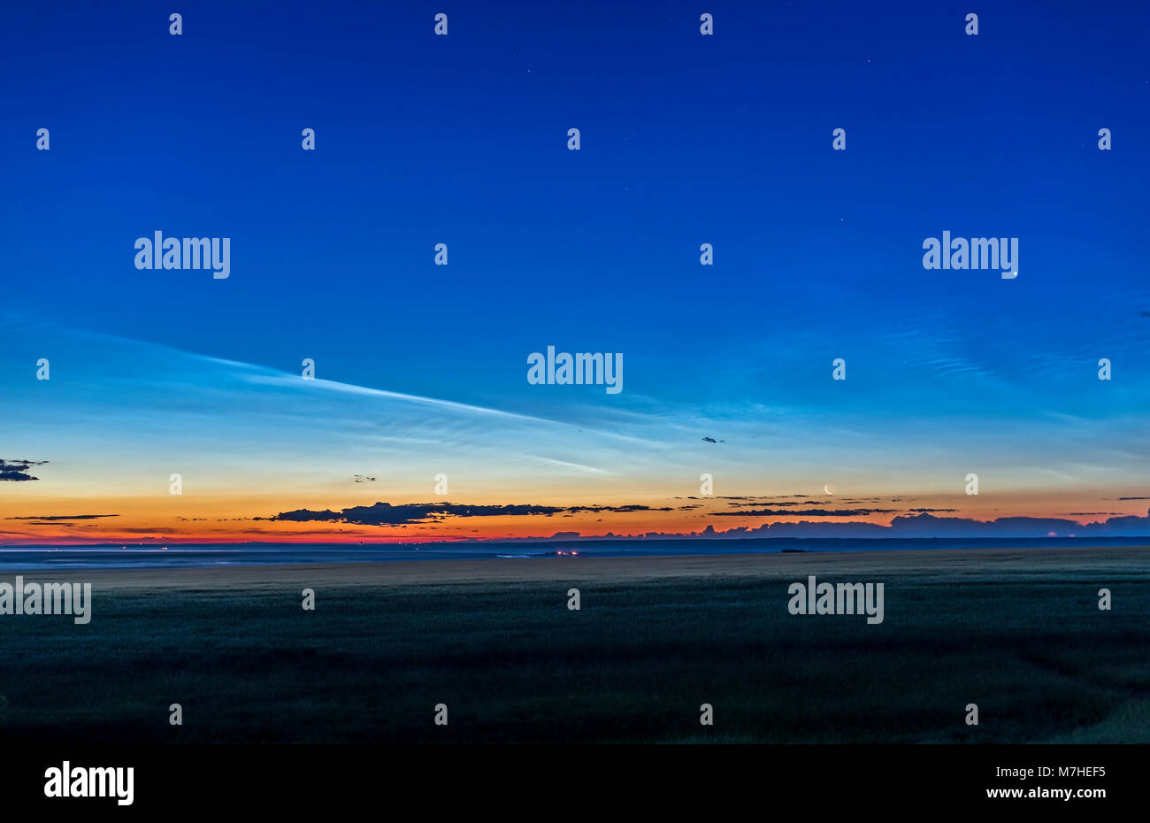 Noctilucent clouds at dawn with the moon and Venus. Stock Photo