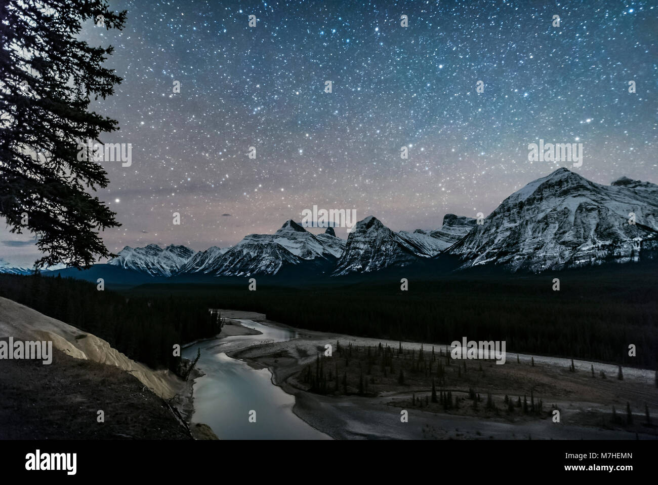 A starry sky over the Athabasca River and continental divide, Alberta, Canada. Stock Photo
