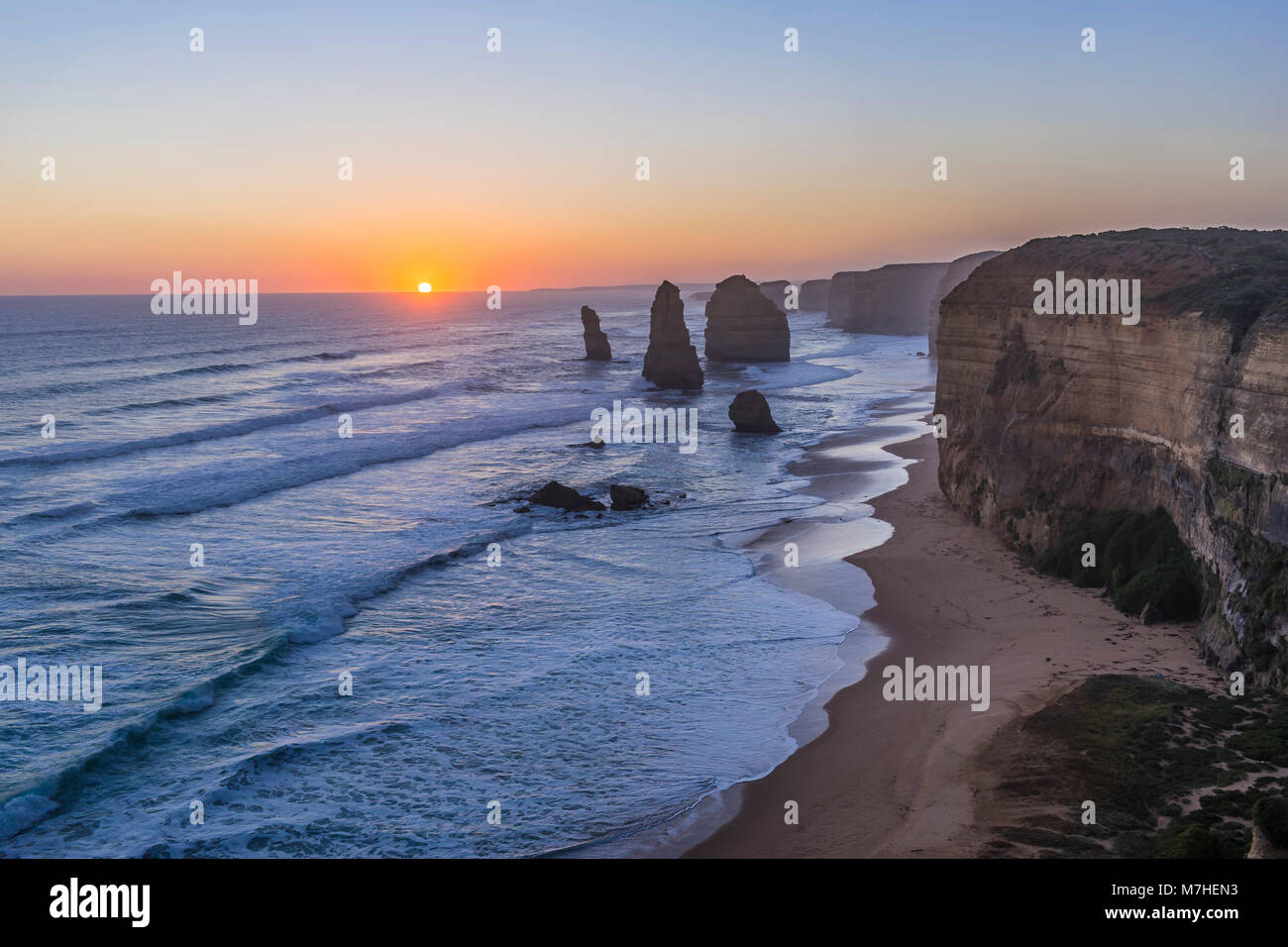 The setting Sun at the Twelve Apostles sea stacks and cliffs on the Great Ocean Road. Stock Photo