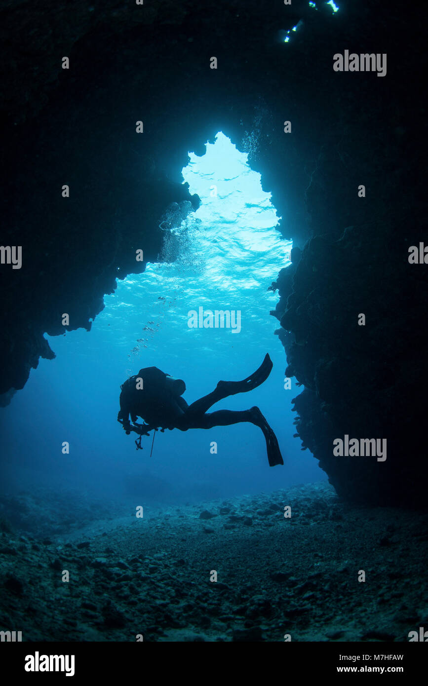A diver exiting a swim through cavern, Kadavu Island, Fiji Stock Photo ...