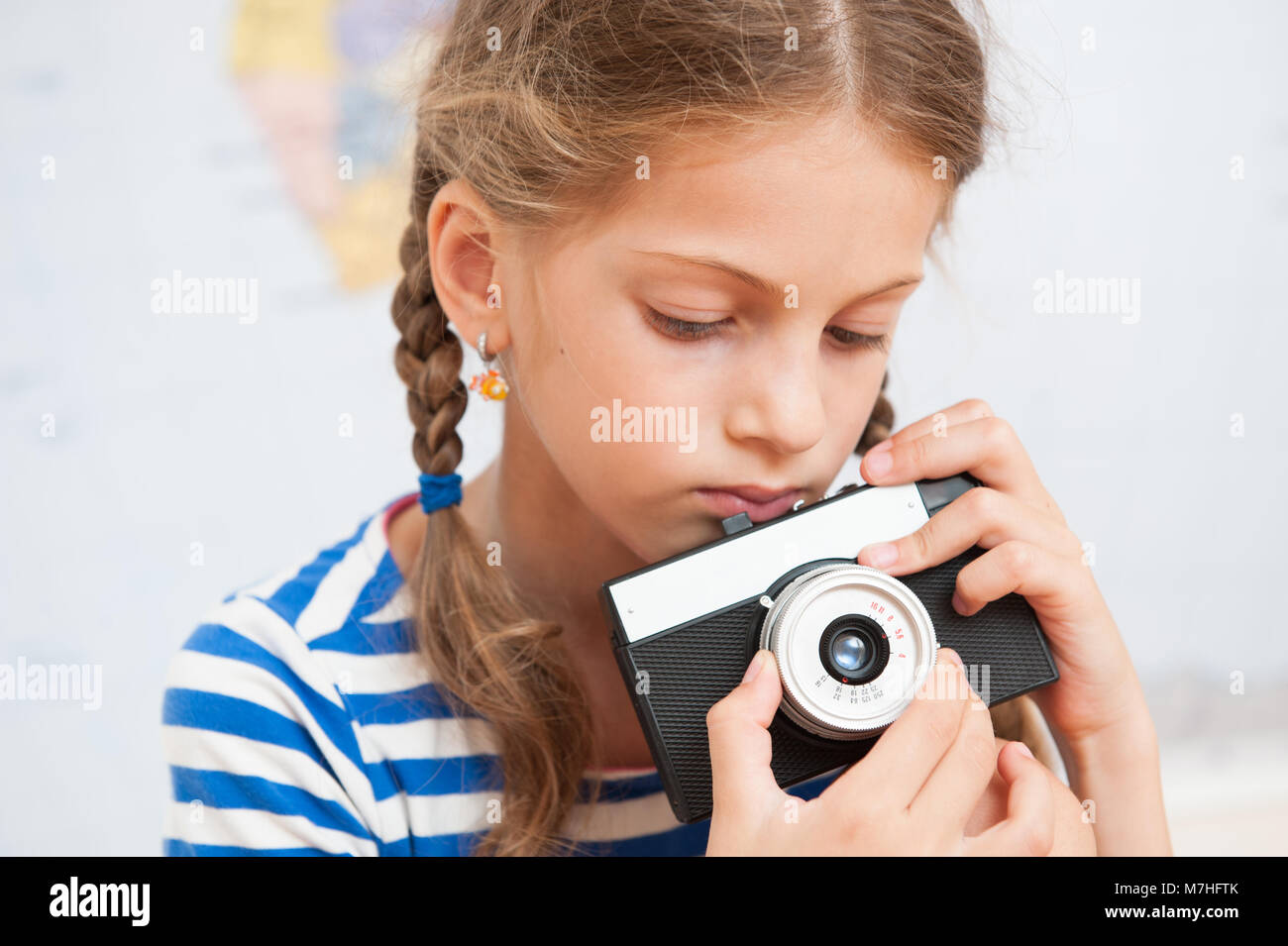 portrait of cute little girl holding a vintage film camera Stock Photo