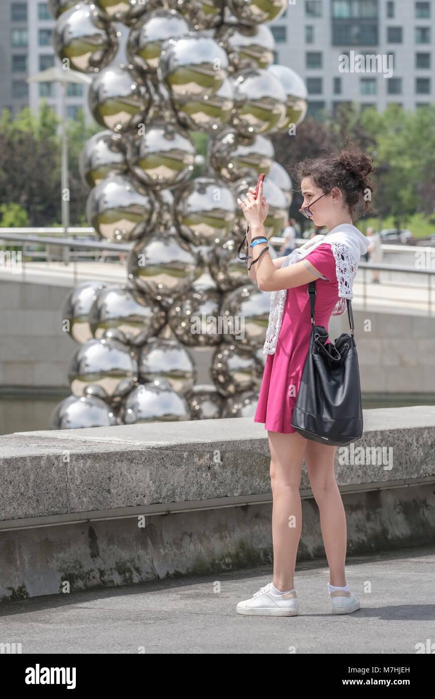 Young lady taking a selfie outside the Silver Balls sculpture of the Guggenheim Musuem, Bilbao, Vizcaya, Pais Vasco, Spain, Stock Photo