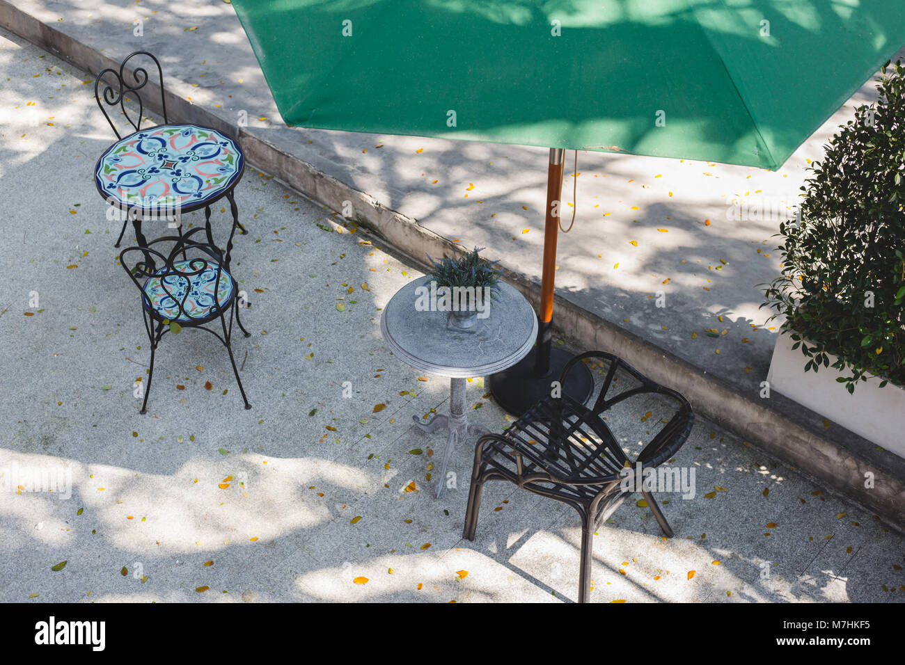 Empty chair and table of coffee shop at outside with green umbrella , top view image Stock Photo
