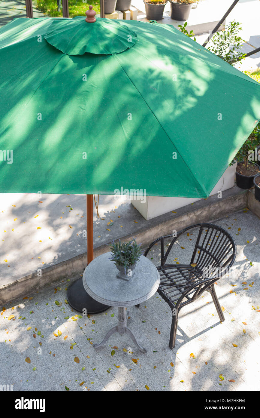Empty chair and table of coffee shop at outside with green umbrella , top view image Stock Photo