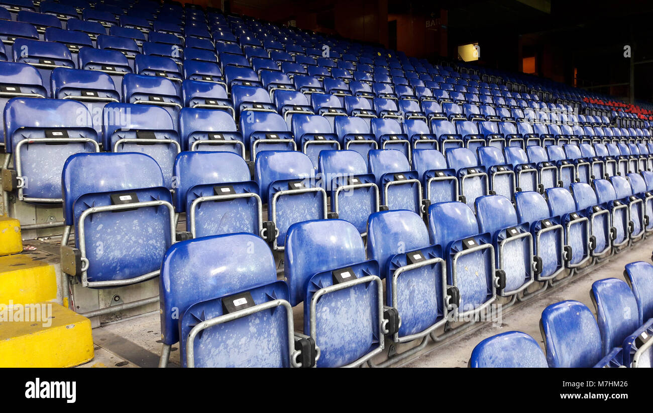 Dark blue rows of seats in a football stadium. Stock Photo