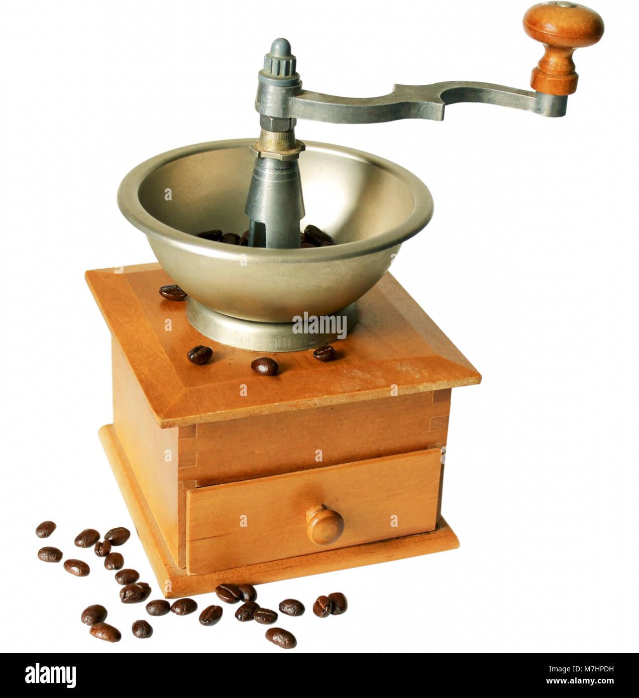 The mechanical hand grinder and coffee beans scattered isolated on