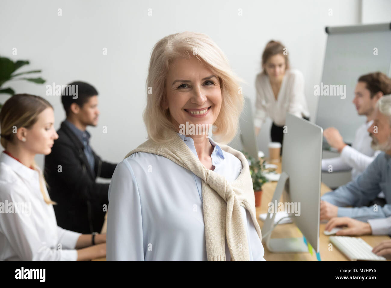Smiling aged company executive or team leader looking at camera Stock ...