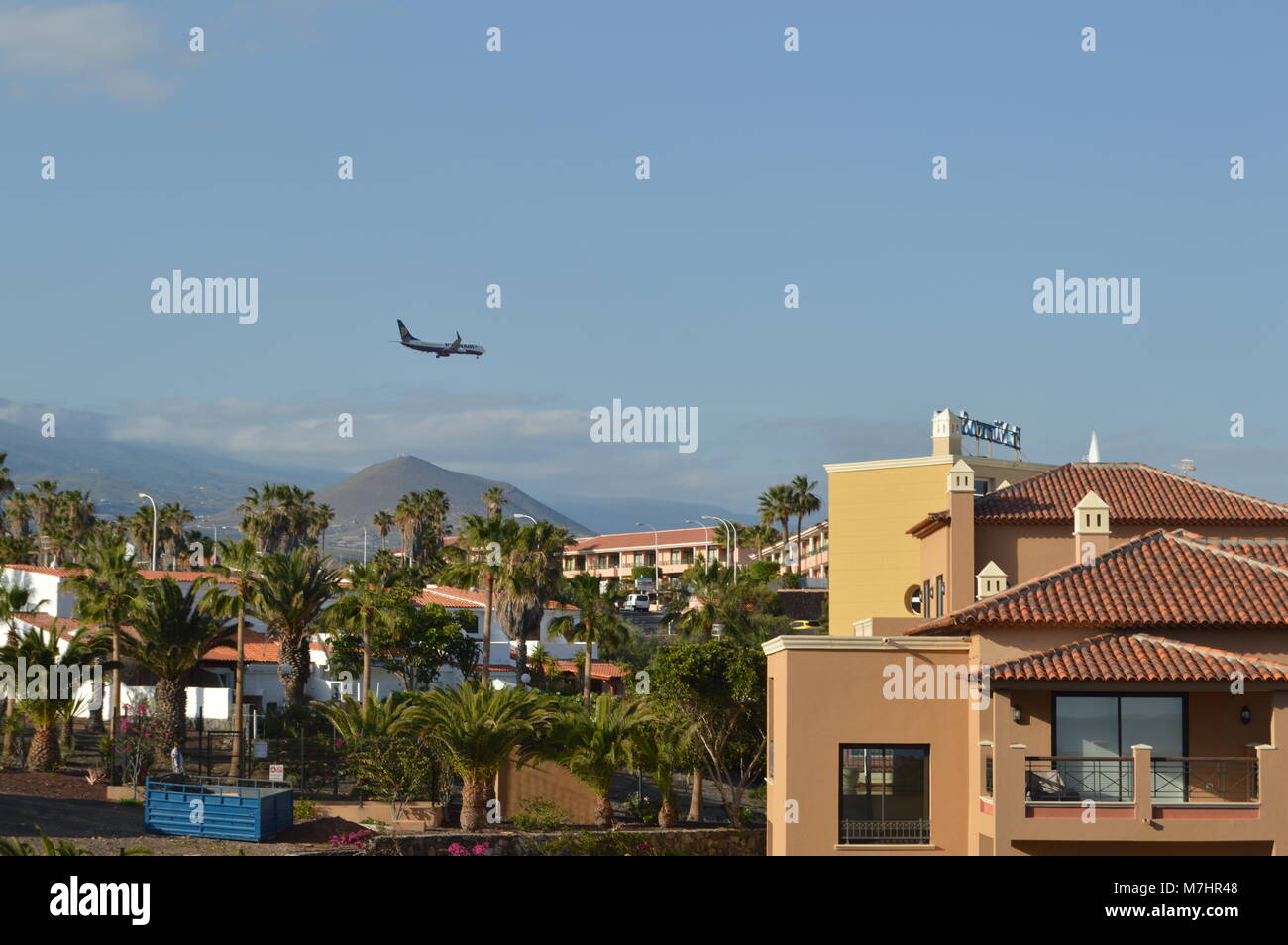 Landing plane above town in Tenerife Stock Photo