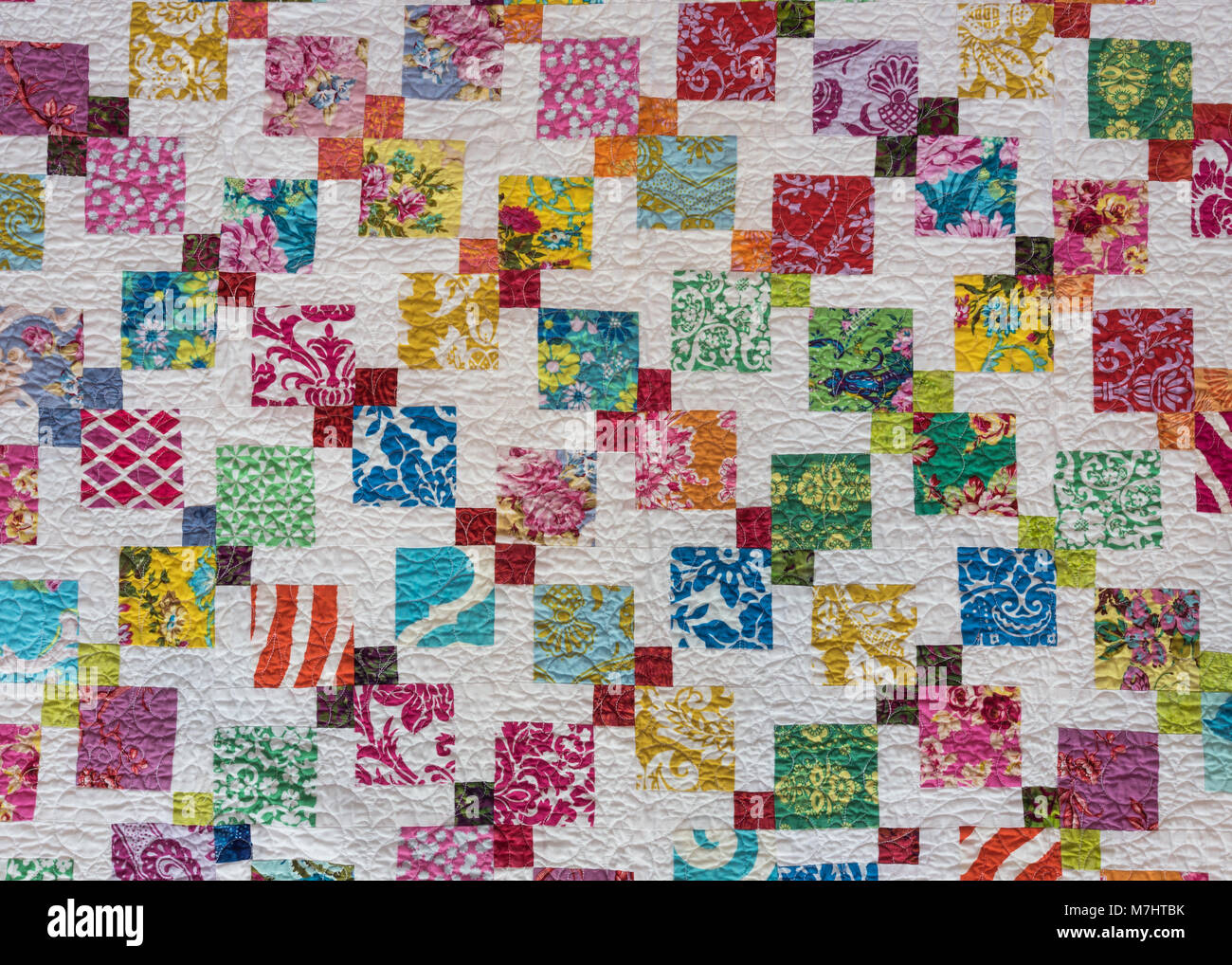 Multi Colored Quilt Squares Scattered Across White Background