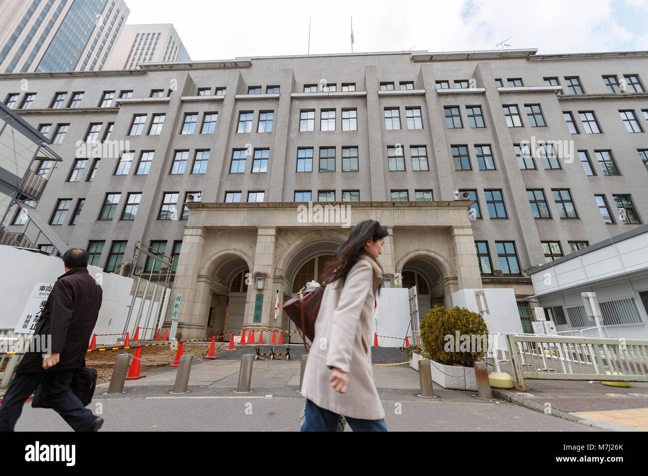 Pedestrians walk past the Ministry of Finance and National Tax Agency of Japan on March 11, 2011, Tokyo, Japan. Japan's Finance Ministry plans to admit to the Parliament tomorrow that it has found deleted content from the documents submitted to lawmakers including parts explaining about the controversial Moritomo Gakuen scandal. Opposition leaders have demanded the resignation of the finance minister Taro Aso. Credit: Rodrigo Reyes Marin/AFLO/Alamy Live News Stock Photo