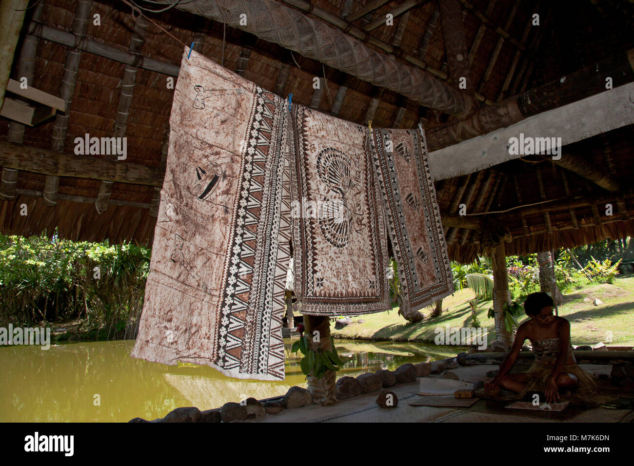 Native girl in traditional costume making tapa cloth at the Arts Village in Pacific Harbour, Fiji. Stock Photo