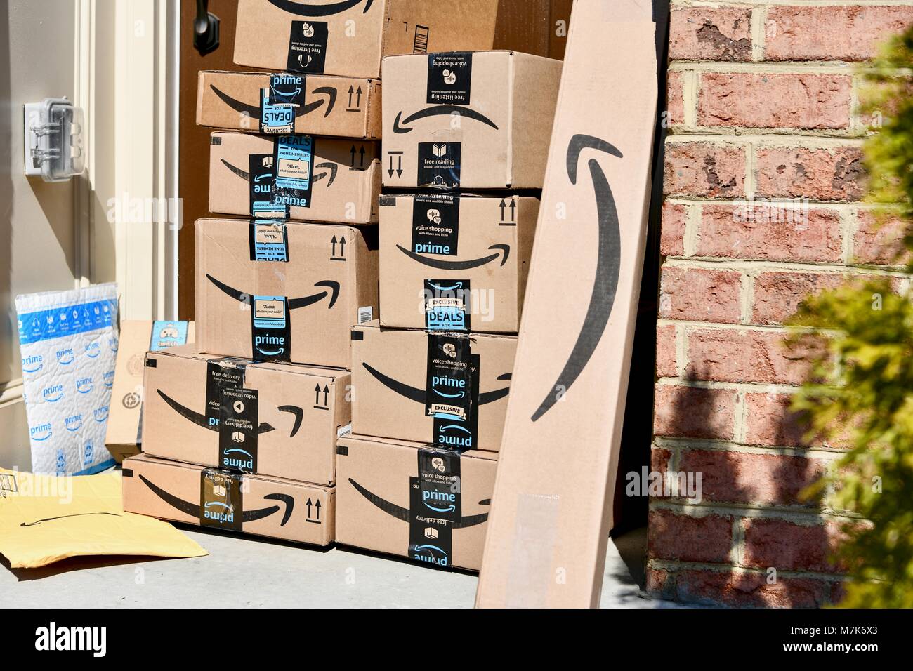 Amazon Prime boxes delivered and stacked at the front door of a residential home, USA Stock Photo