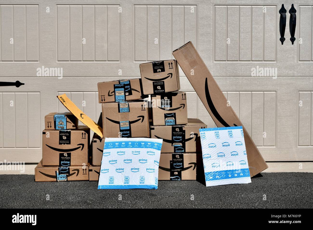 Shipment of Amazon Prime boxes and packages delivered and left in front of garage at a residential home, USA Stock Photo