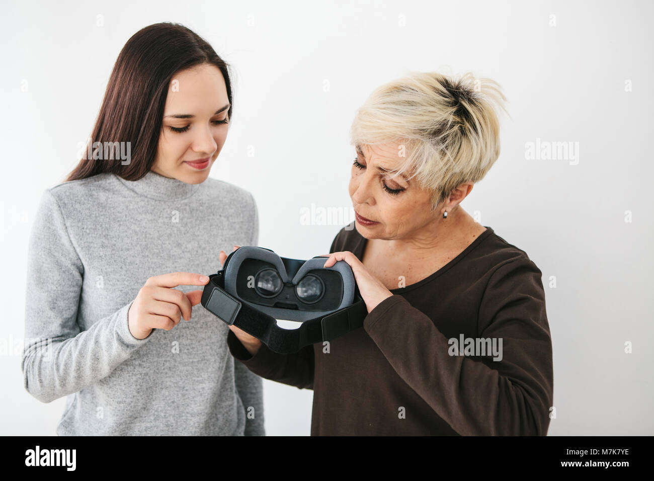 A young girl explains to an elderly woman how to use virtual reality