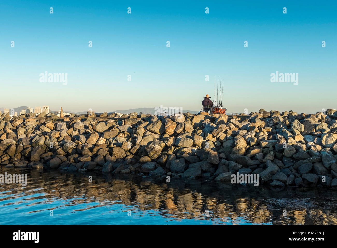 SAN DIEGO, CALIFORNIA, USA Man fishing on the breakwater off Shelter