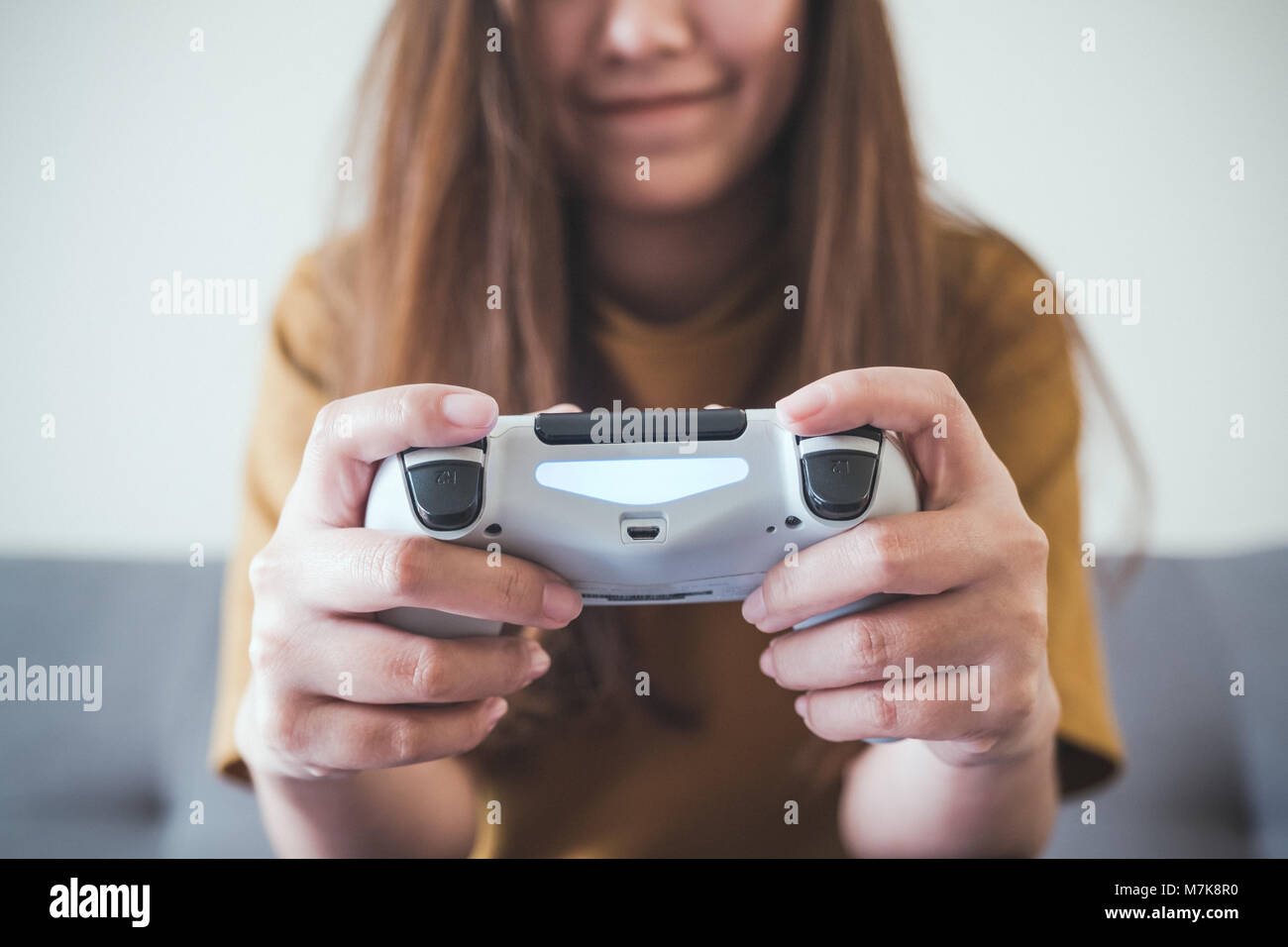 Closeup image of an asian woman holding the game controller while Stock  Photo - Alamy