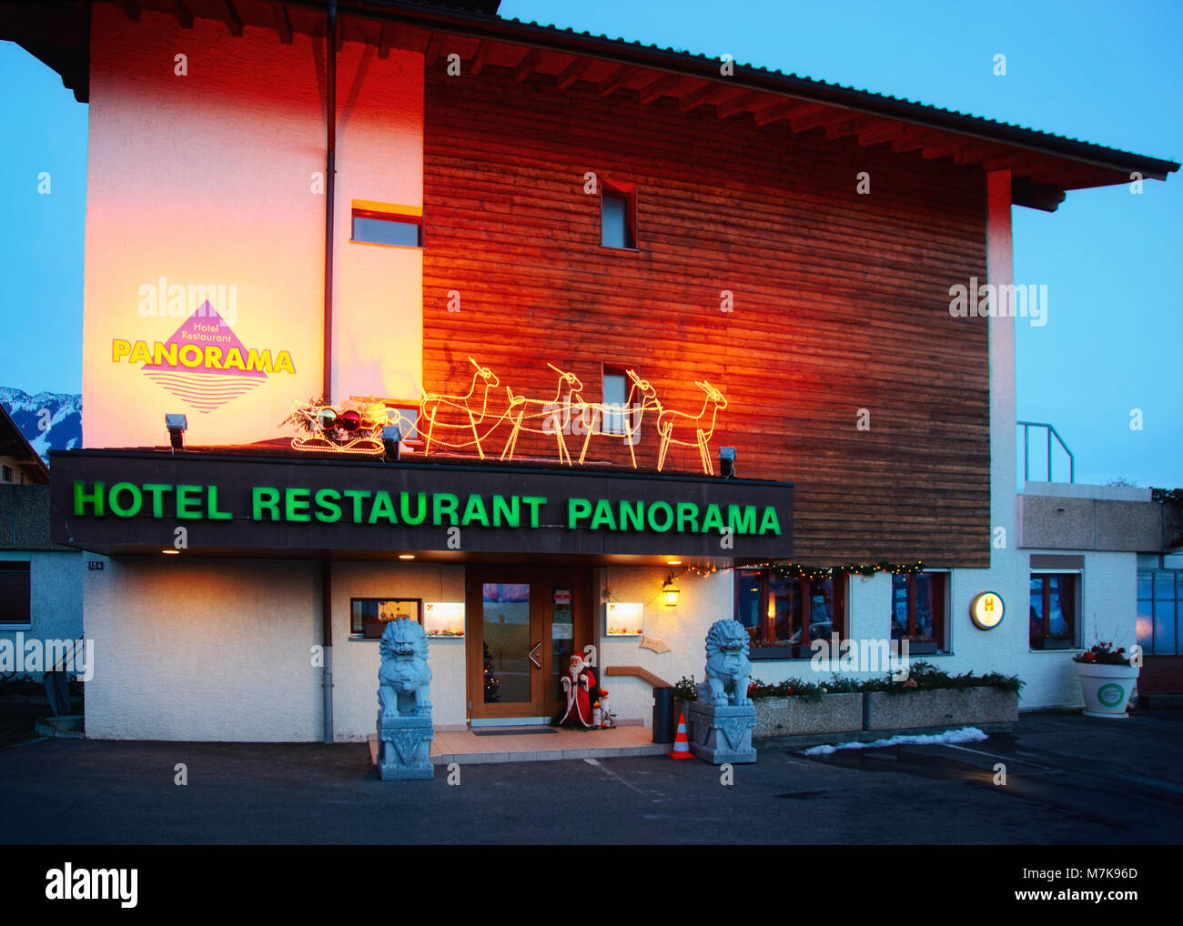 Sigrilwil, Switzerland - January 1, 2014: Hotel building placed at Swiss Alps mountains and Thun lake, Switzerland in winter. In the evening Stock Photo