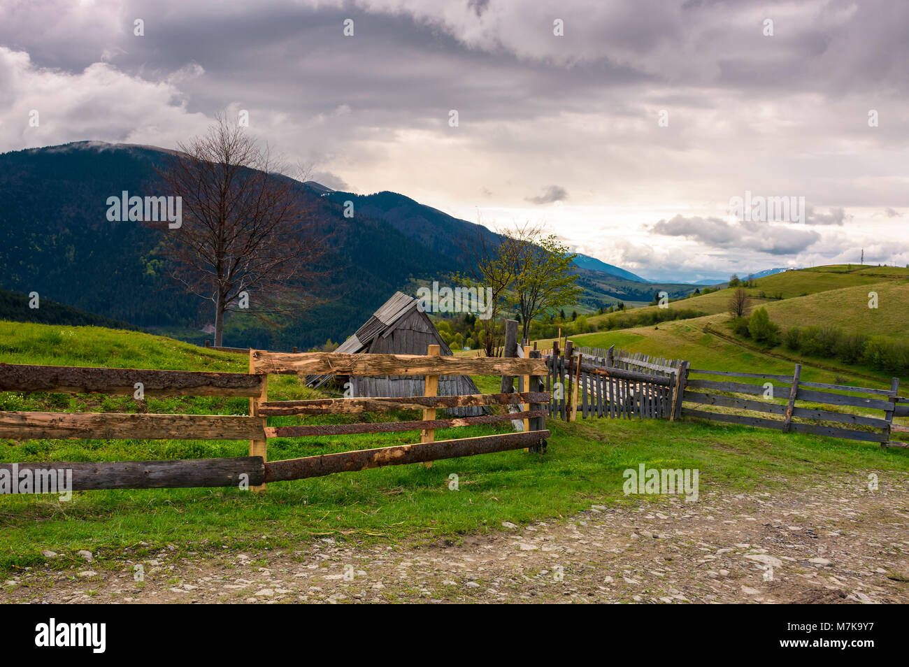 lovely rural landscape in Carpathians. wooden fence along the road on a cloudy day in mountains Stock Photo