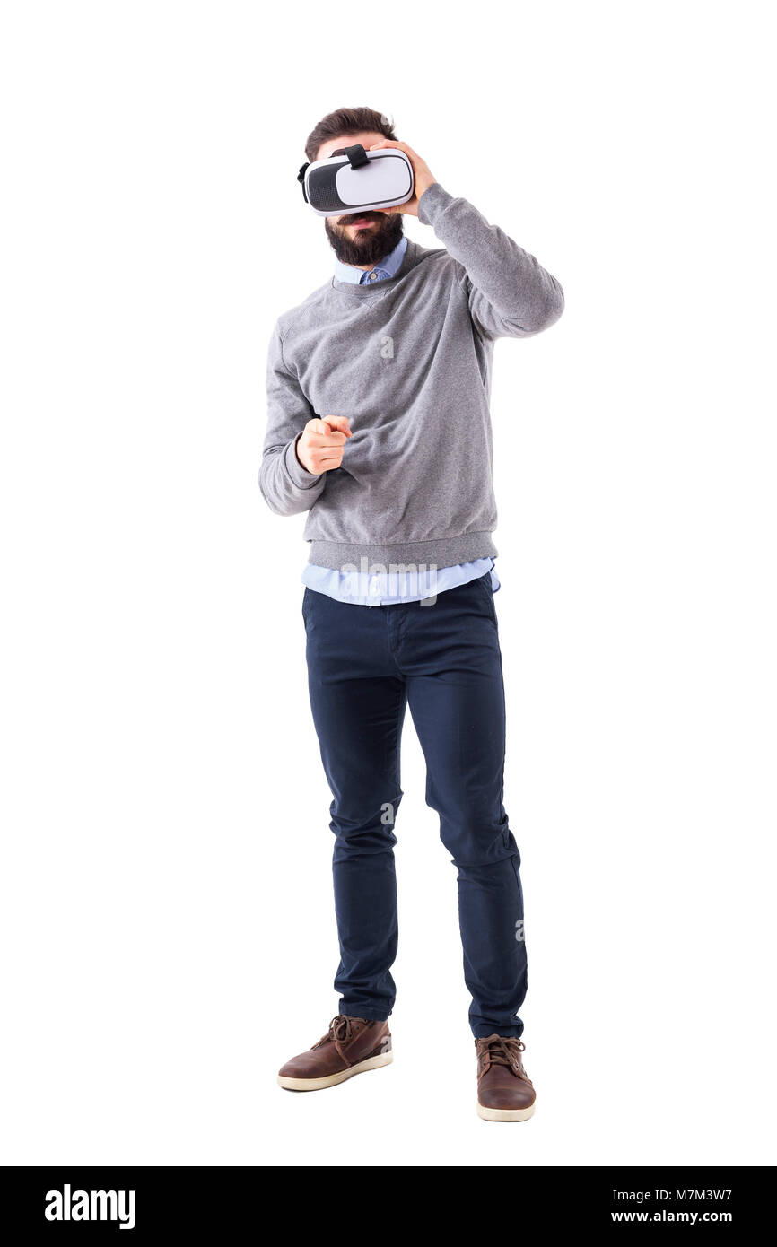 Young adult man holding virtual reality headset pointing finger at