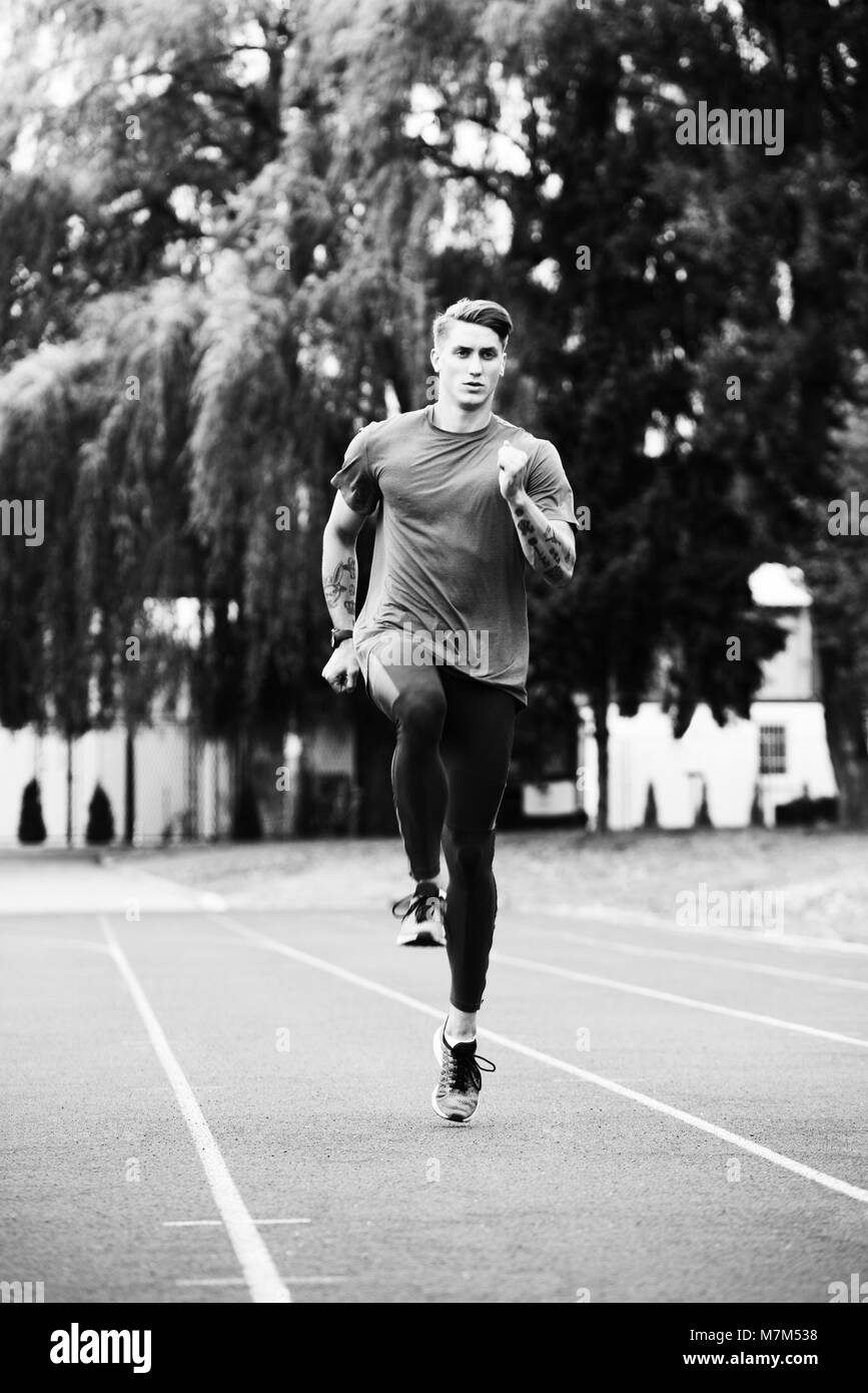 Young Athlete Man Running on Track In Park Run Athletics Race Stock