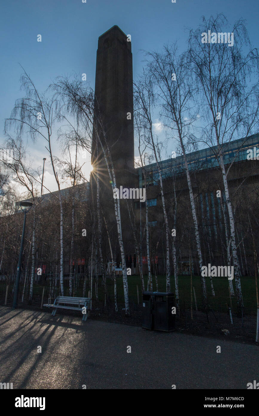 The early morning rising sun peeps past the Tate Modern Stock Photo