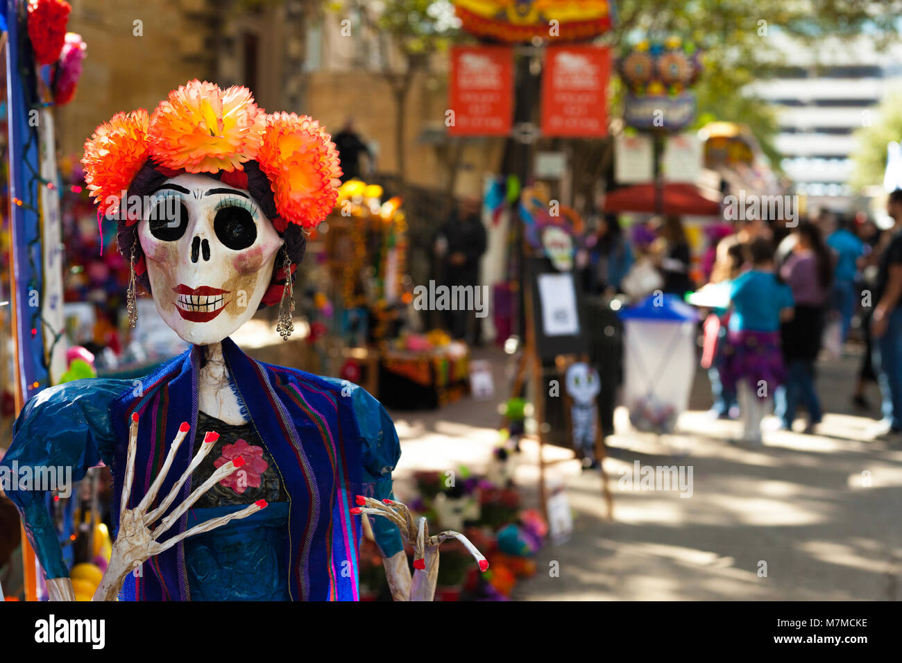 Skeleton mannequin painted and decorated with orange paper mache flowers and earrings for Dia de los Muertos/ Day of the Dead Stock Photo