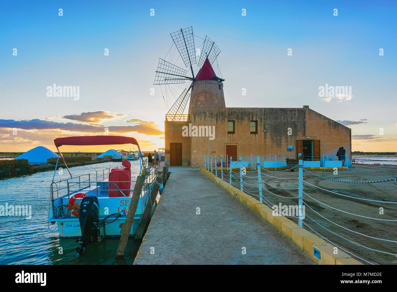 Marsala, Italy - September 19, 2017: Sunset at Windmill and the salt evoporation pond in Marsala, Sicily island in Italy Stock Photo