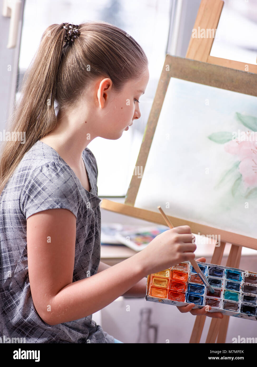 Artist painting on easel in studio. Girl paints with brush Stock Photo ...