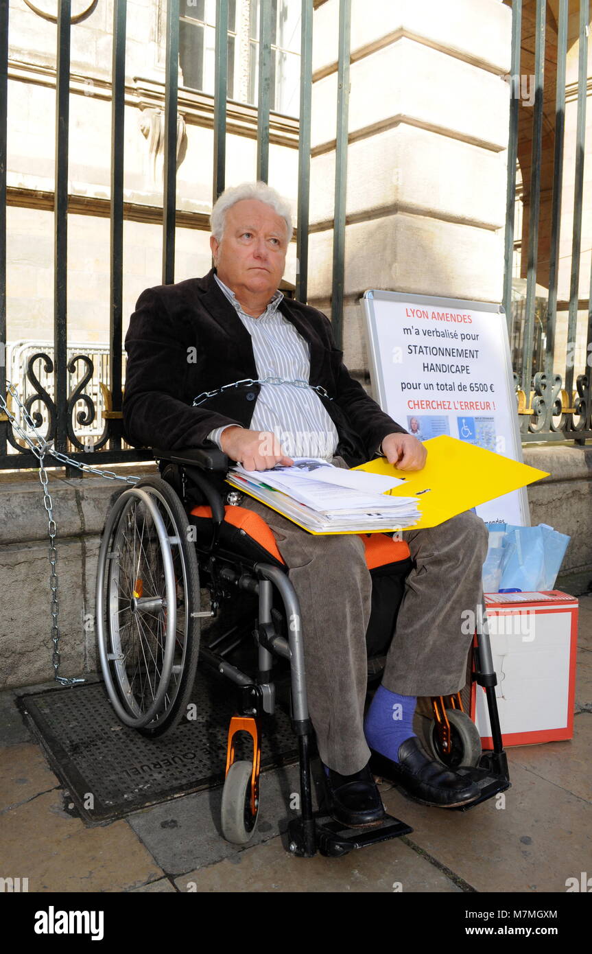 Jean-Claude Mouton, disabled car driver, shackles himself to protest  against parking ticket policy in Lyon, France Stock Photo - Alamy