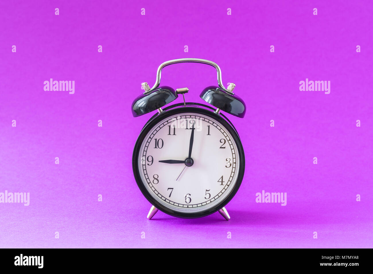 Black modern alarm clock set at nine o'clock, isolated, work school
