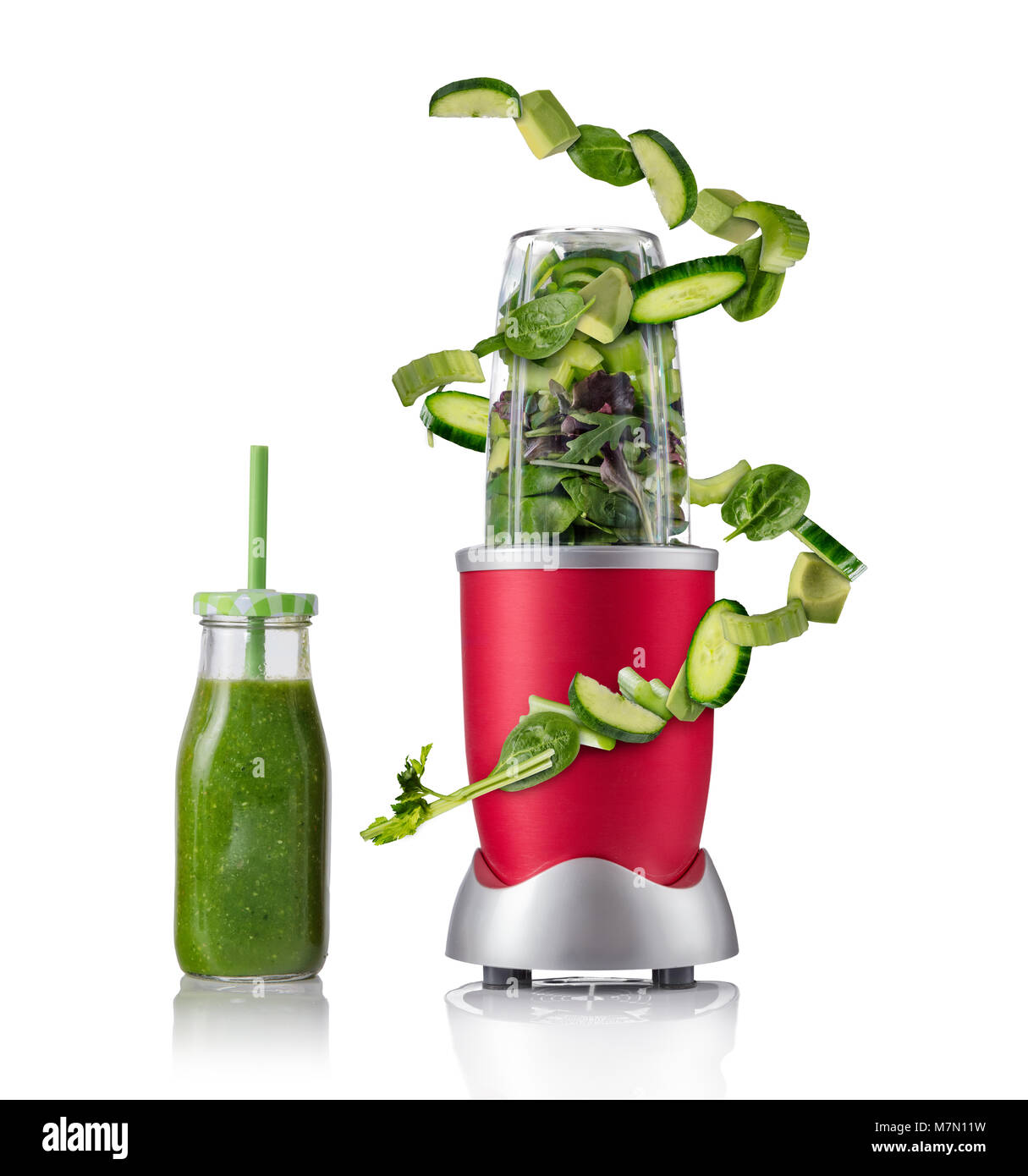 Smoothie maker mixer with vegetable flying ingredients, isolated on