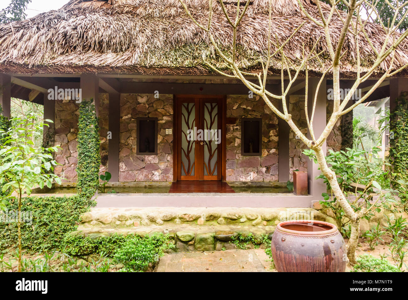 One of the thatched hotel bungalows in the Pilgrimage Hotel, Hue, Vietnam Stock Photo