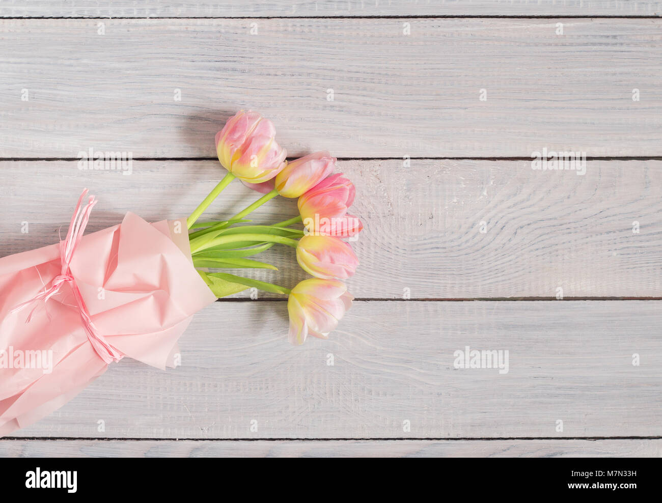 Bouquet of pink tulips on a white wooden table Stock Photo - Alamy