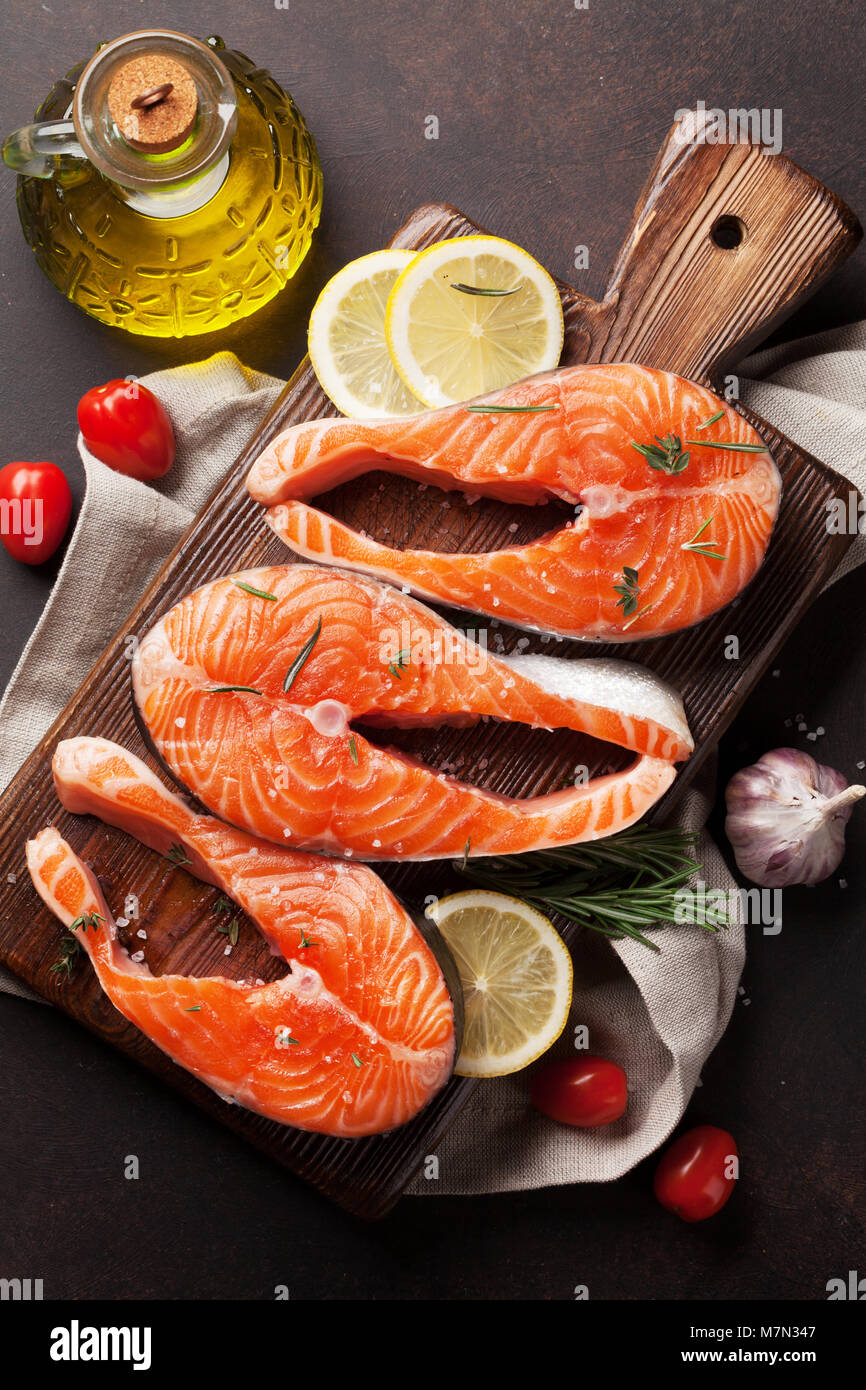 Raw salmon fish fillet with spices cooking on cutting board. Top view ...