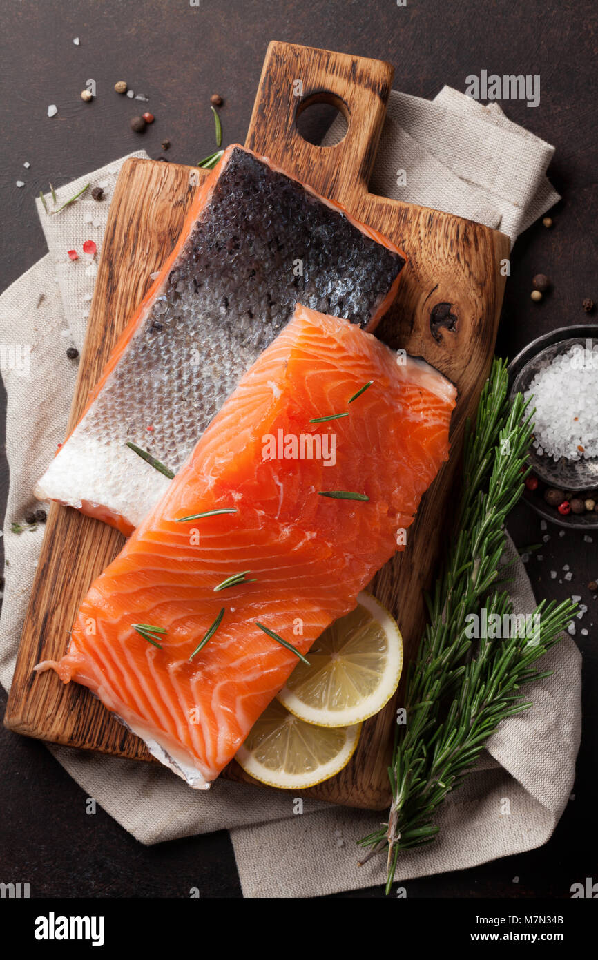 Raw salmon fish fillet with spices cooking on cutting board. Top view ...