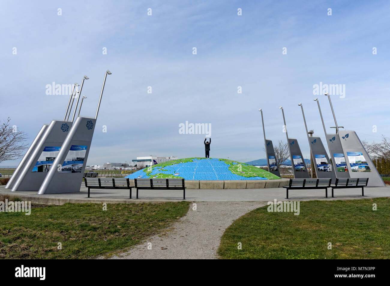 Boy standing on top of a three dimensional map of the world in Larry Berg Flight Path Park, Richmond, BC, Canada Stock Photo