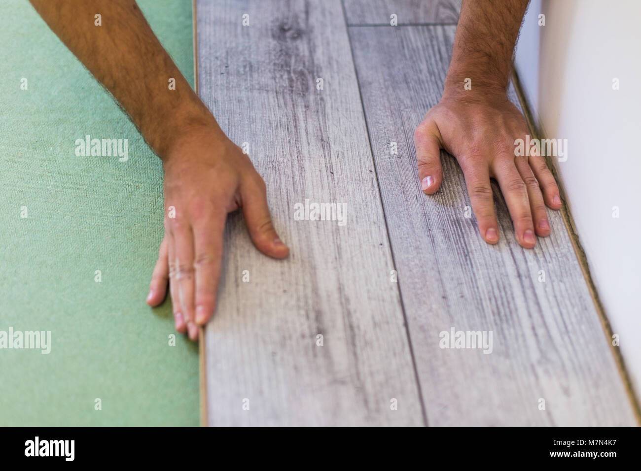 Handyman Laying Down Laminate Flooring Boards While Renovating A