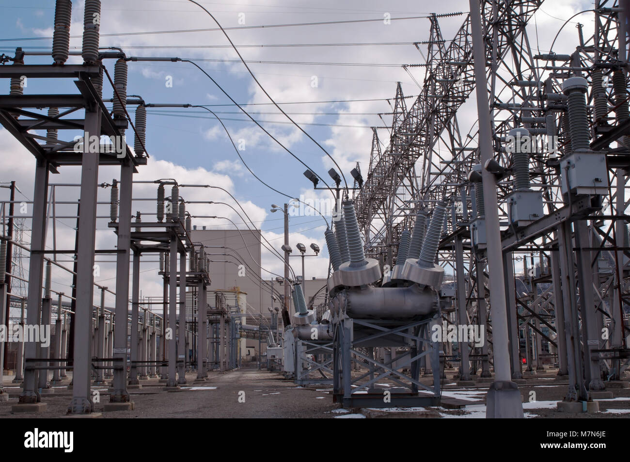 A high voltage electricity power sub station under a bright blue sky with white clouds Stock Photo