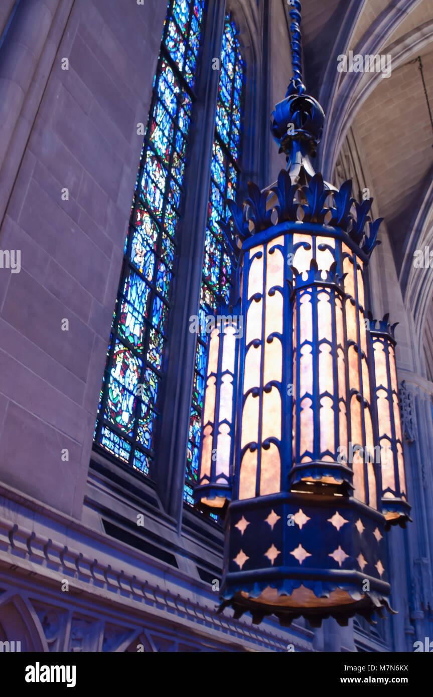 Stained glass windows and a hanging chandelier from inside Heinz Chapel