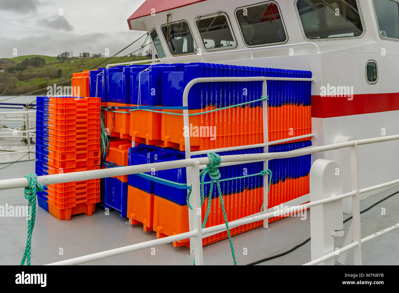 New fish boxes stacked on the deck of a commercial fishing trawler moored in Union Hall, County Cork, Ireland. Stock Photo